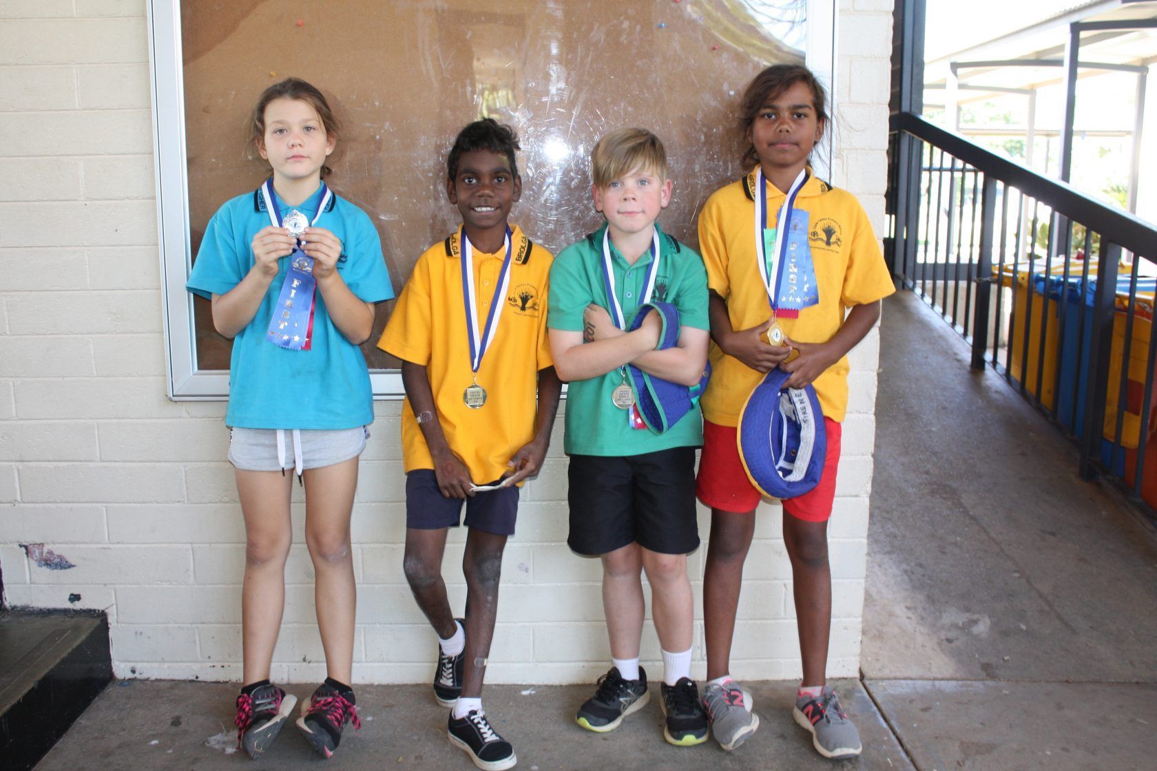 A group of children standing next to each other wearing medals.