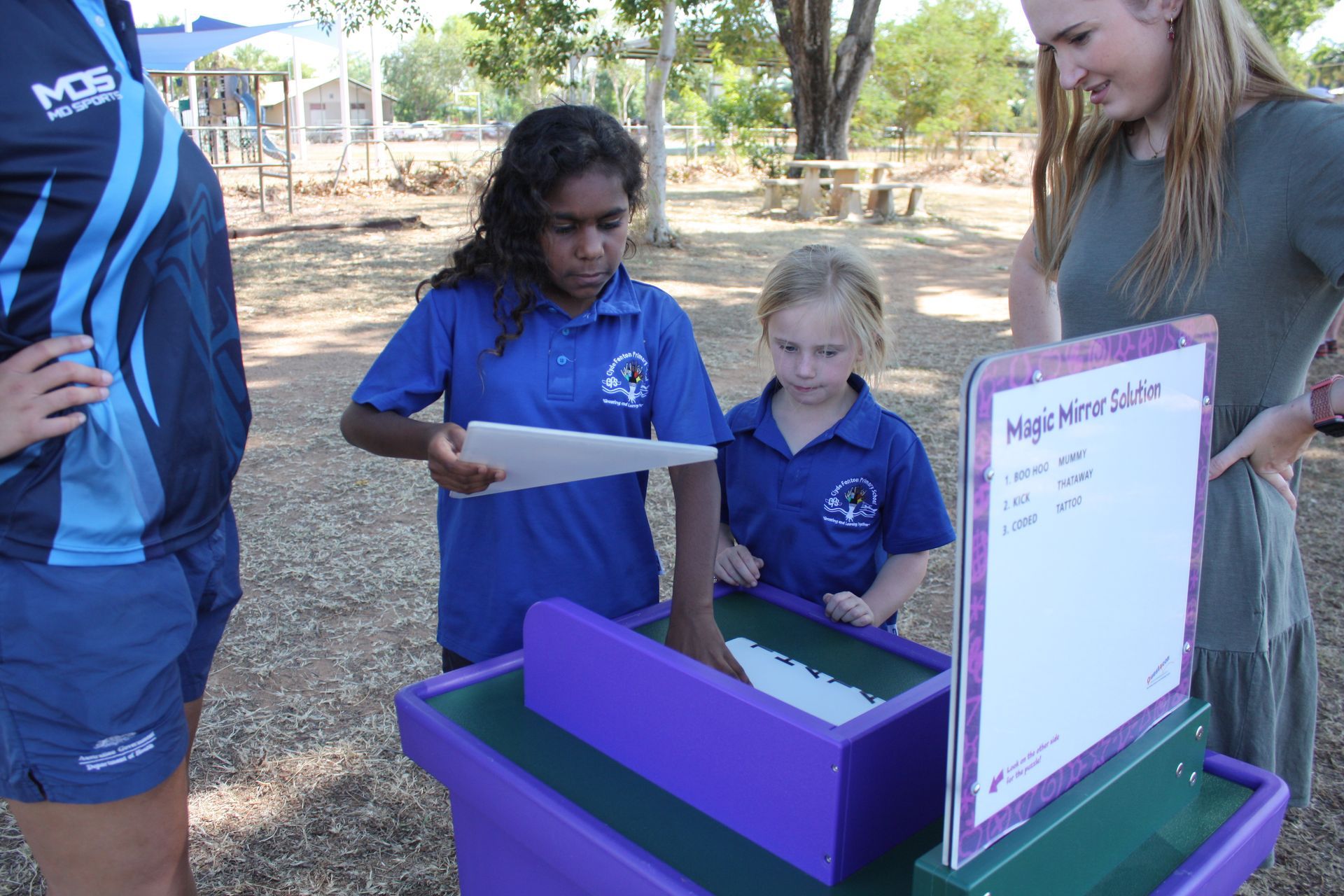 A group of children are looking at a purple box.