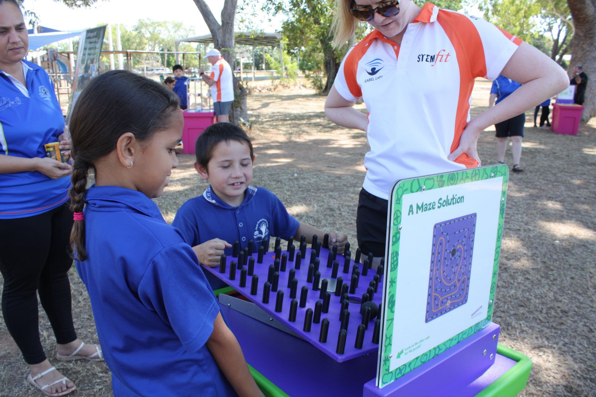 A girl and a boy are playing a game of chess outside
