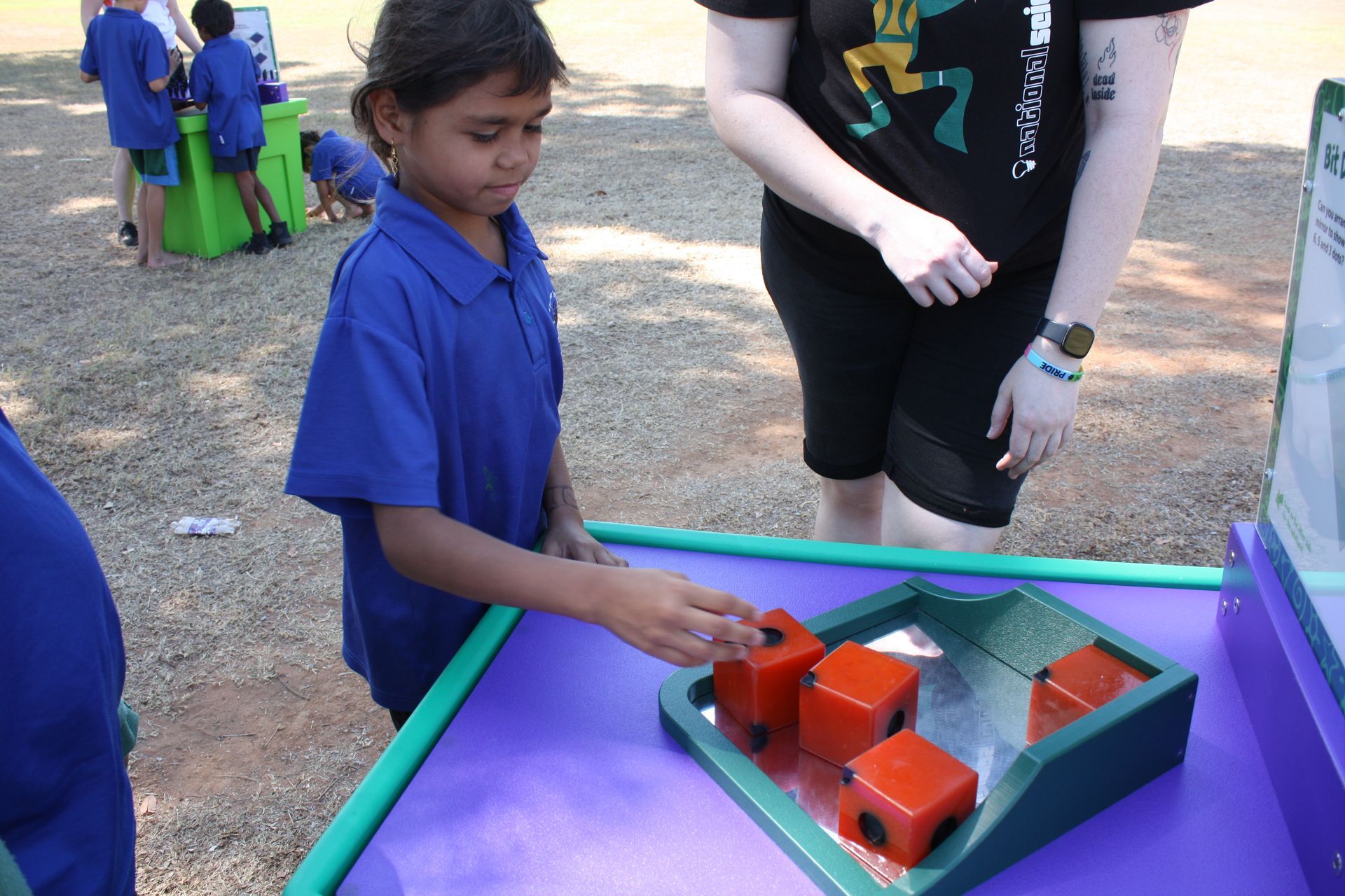 A girl in a blue shirt is playing with a toy