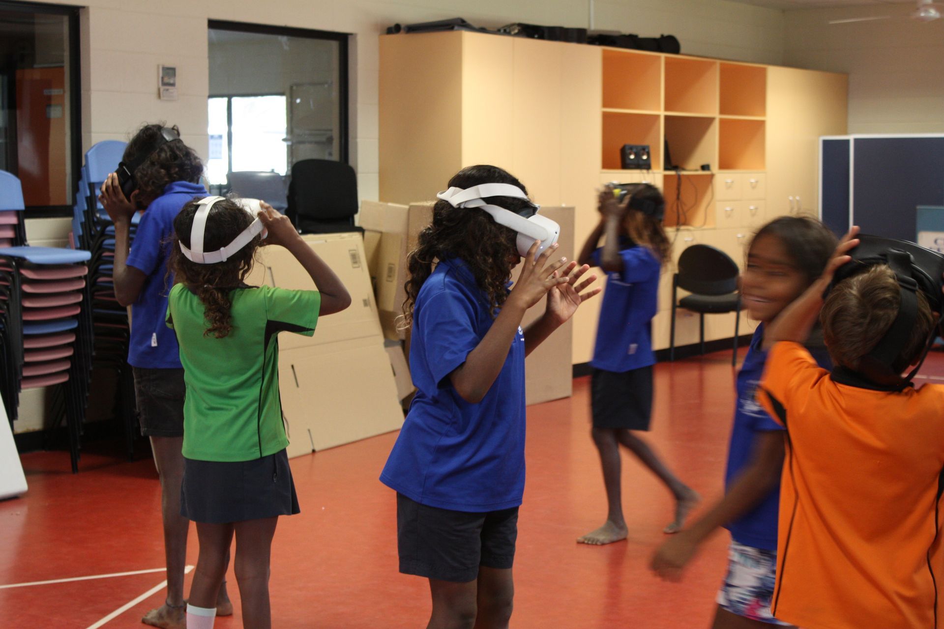A group of children wearing virtual reality headsets in a room