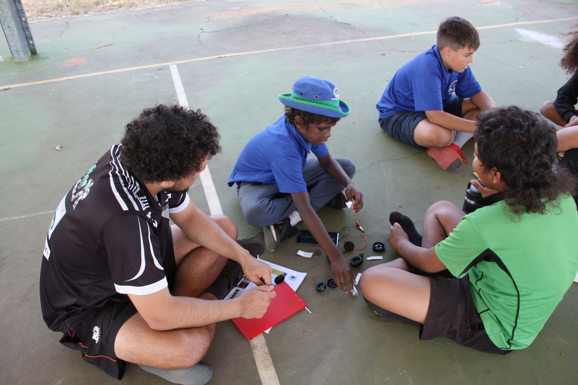 A group of children are sitting on the ground playing a game.