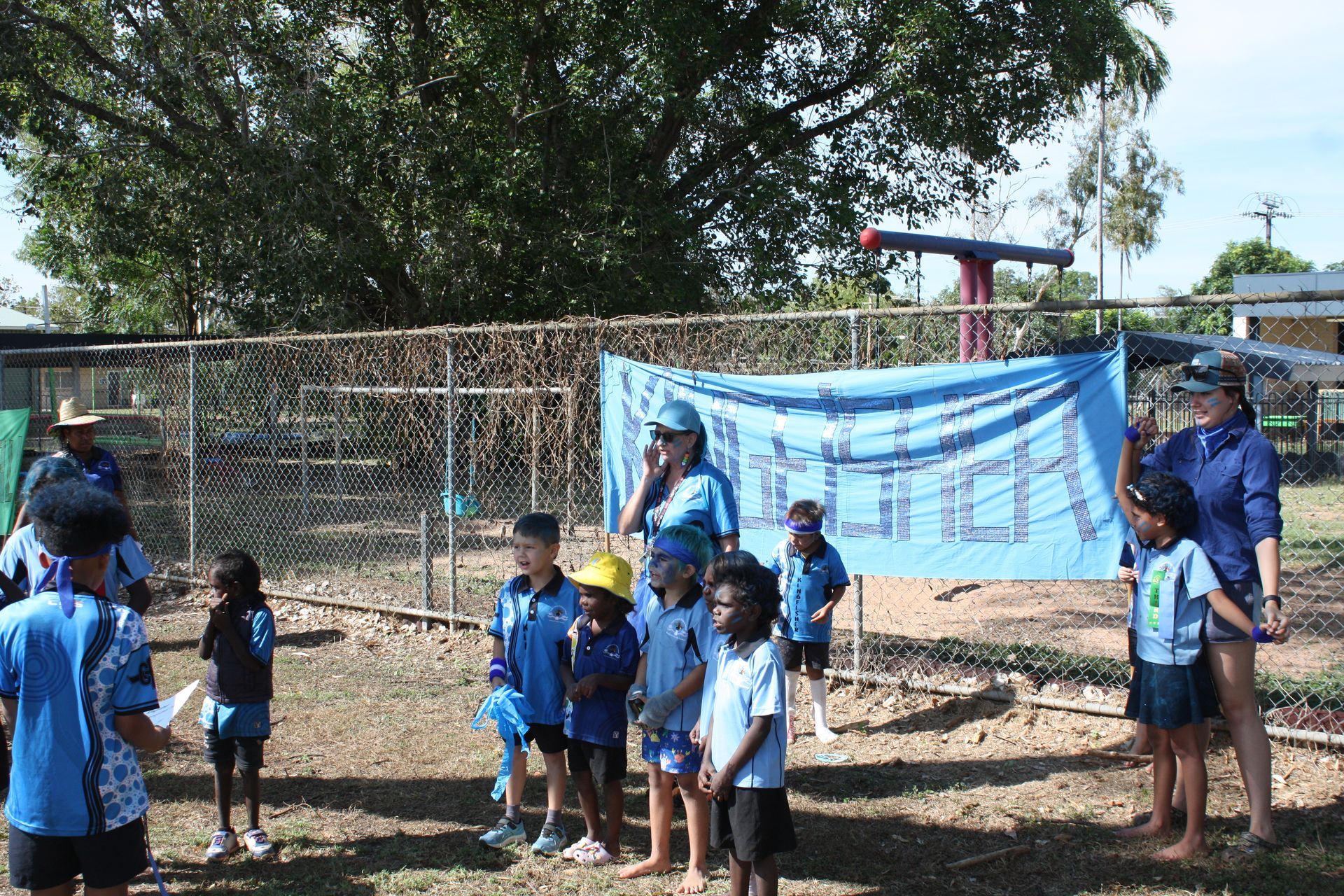 A group of children standing in front of a sign that says lunch