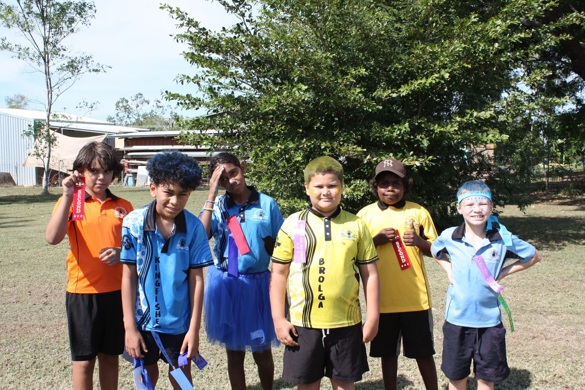 A group of young boys are posing for a picture in a field.