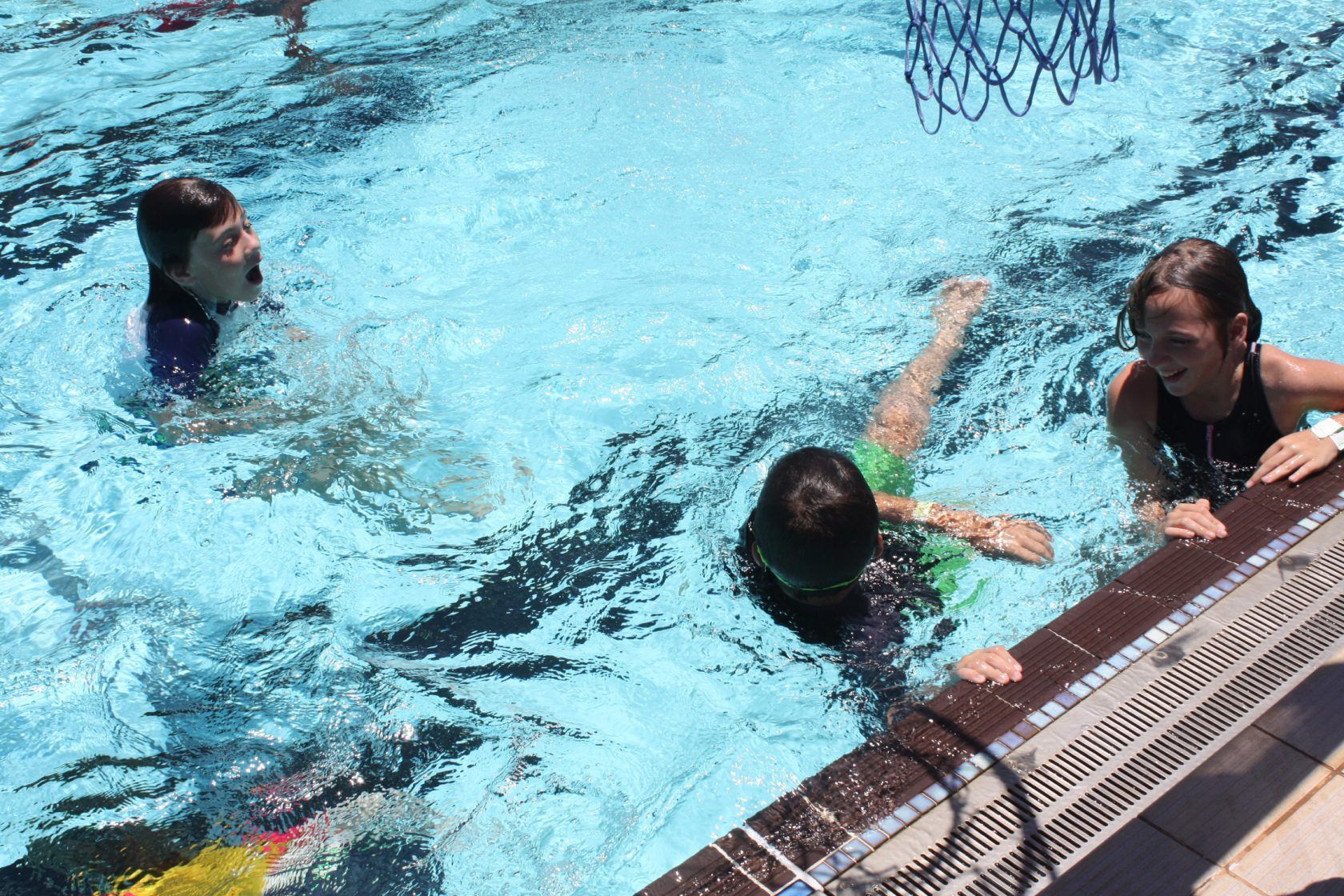 A group of children are playing in a swimming pool.