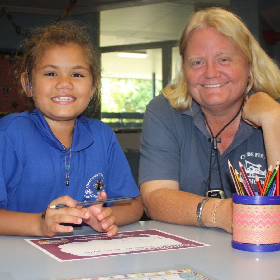 A woman and a little girl are sitting at a table
