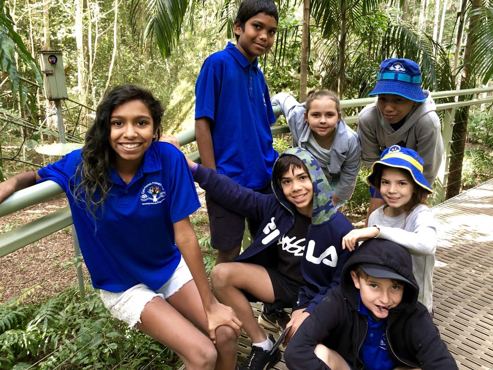 A group of children are posing for a picture in the woods.