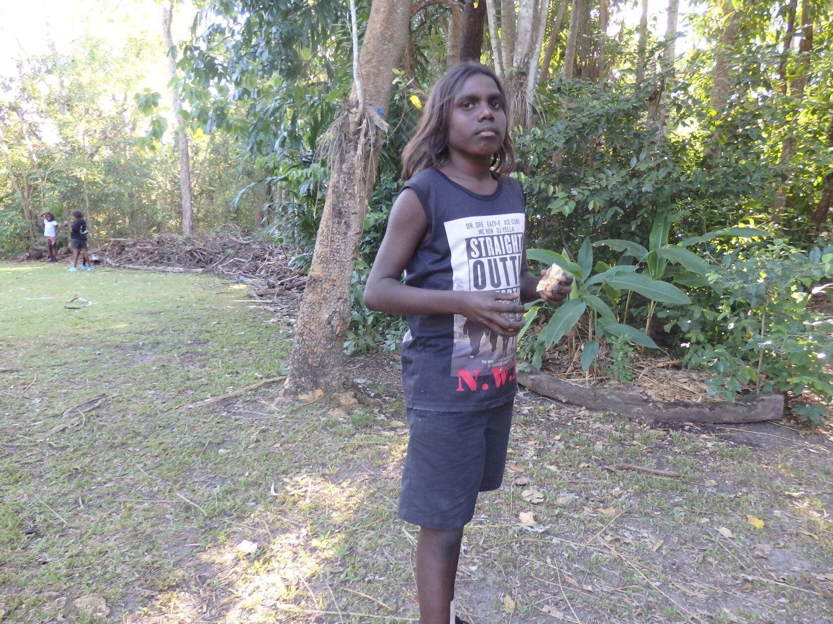 A young boy wearing a black tank top that says ' brave ' on it