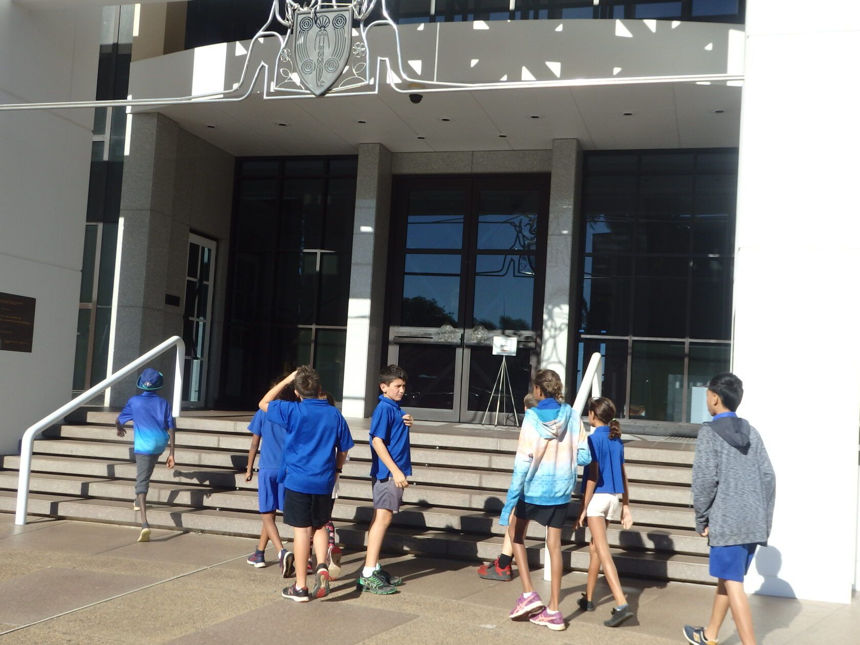 A group of children are standing in front of a building