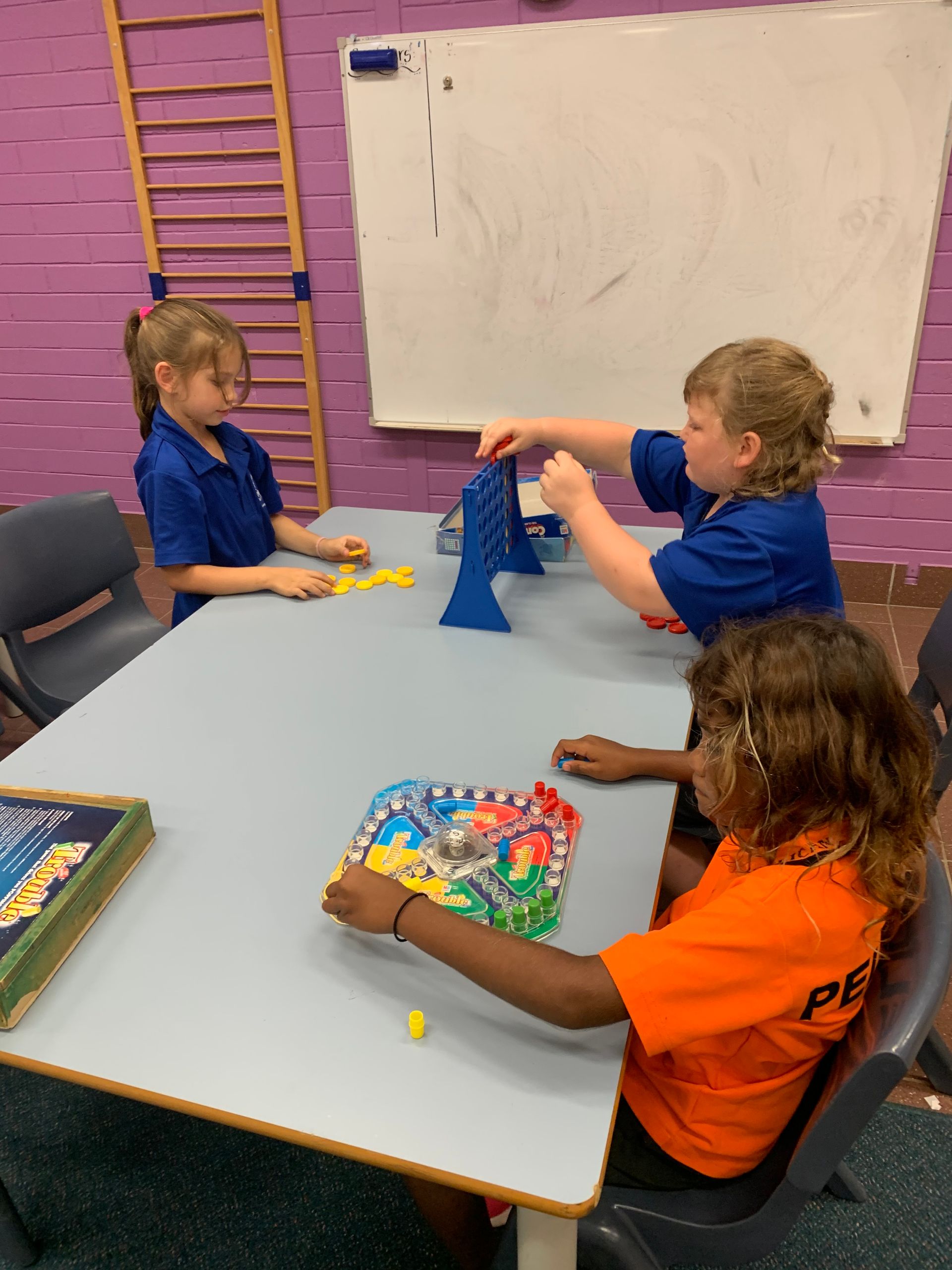 A group of children are playing a game at a table.