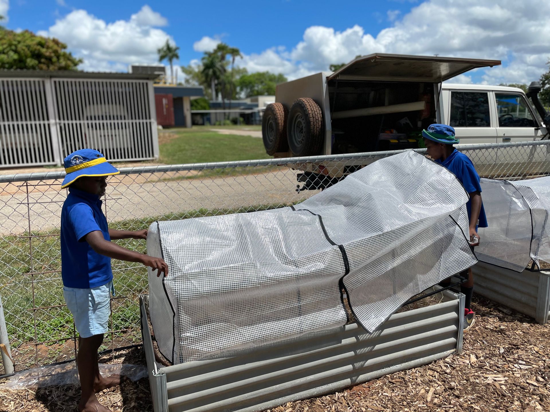 Two men are standing next to each other in front of a truck.