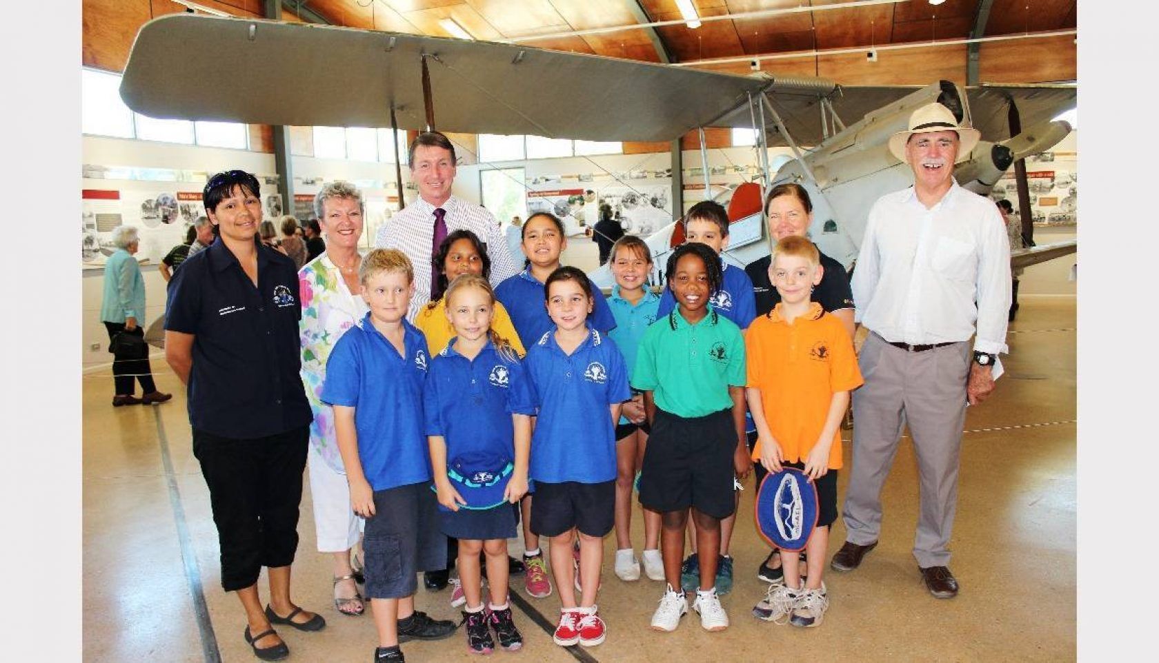 A group of people posing for a picture in front of an airplane