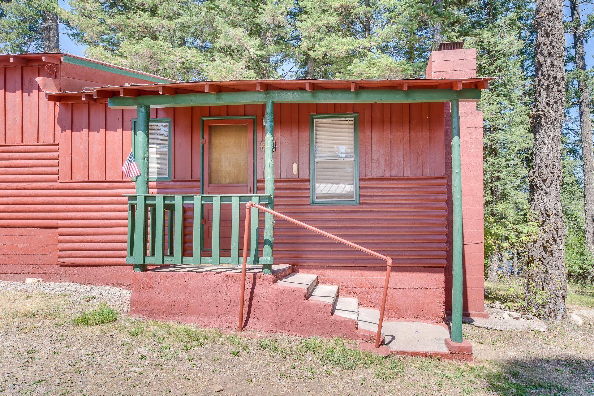 A red house with a green porch and stairs