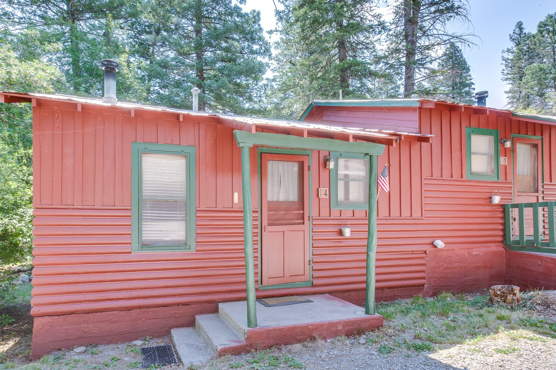 A small red house with a porch and stairs