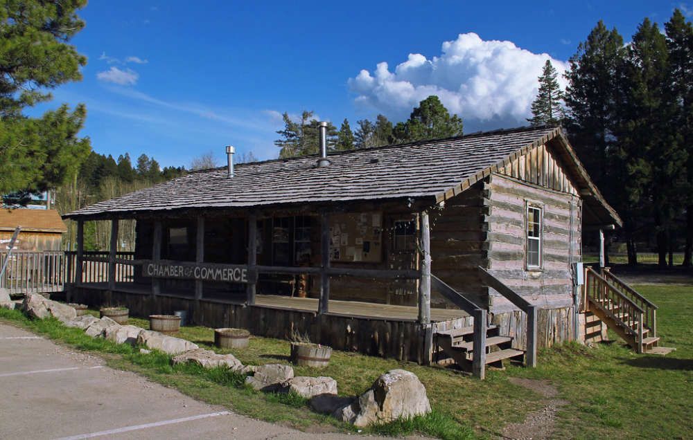 A log cabin with a porch and stairs in front of it
