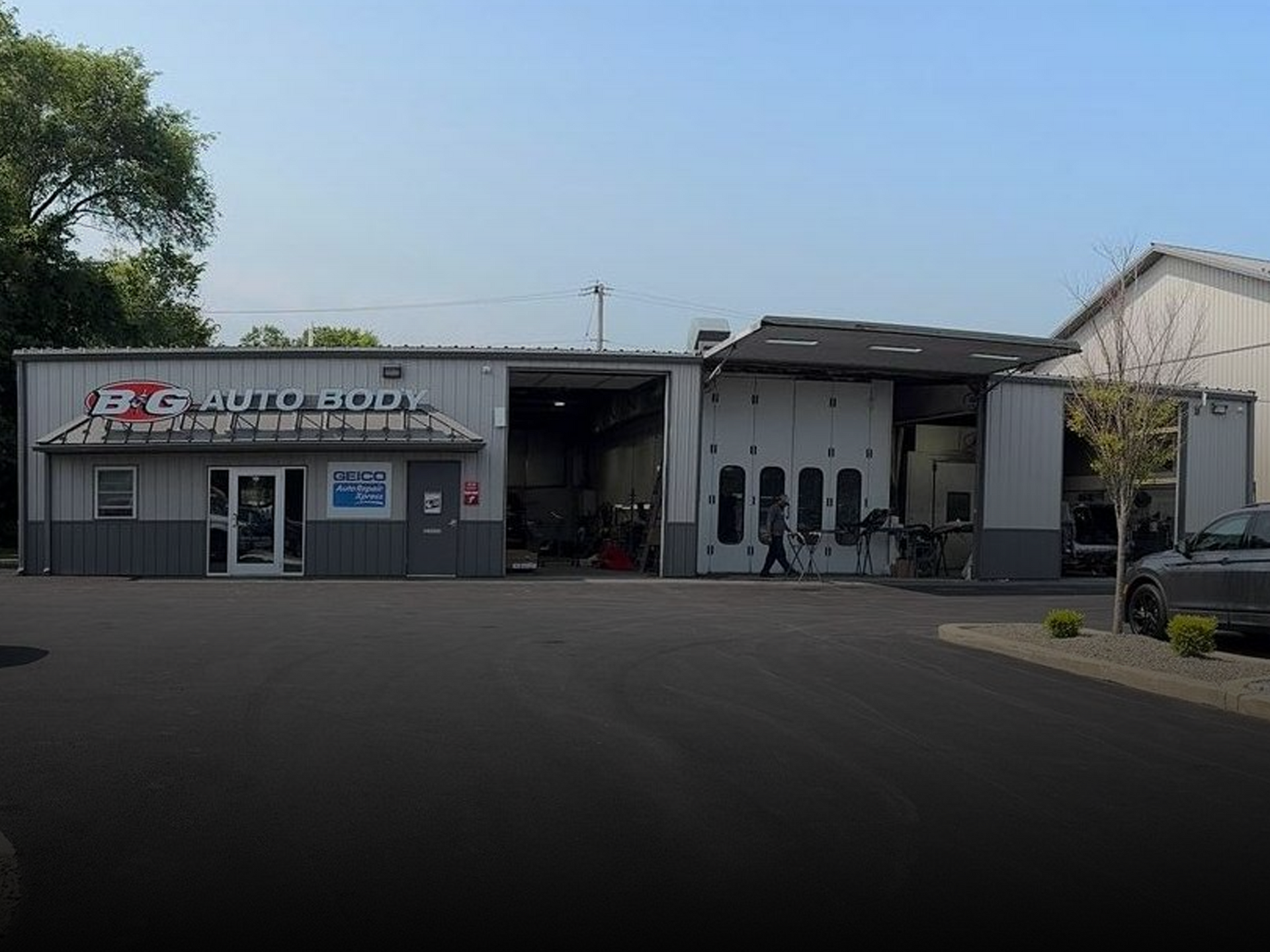 B&G Auto Glass collision repair shop exterior with open garage and service bays.