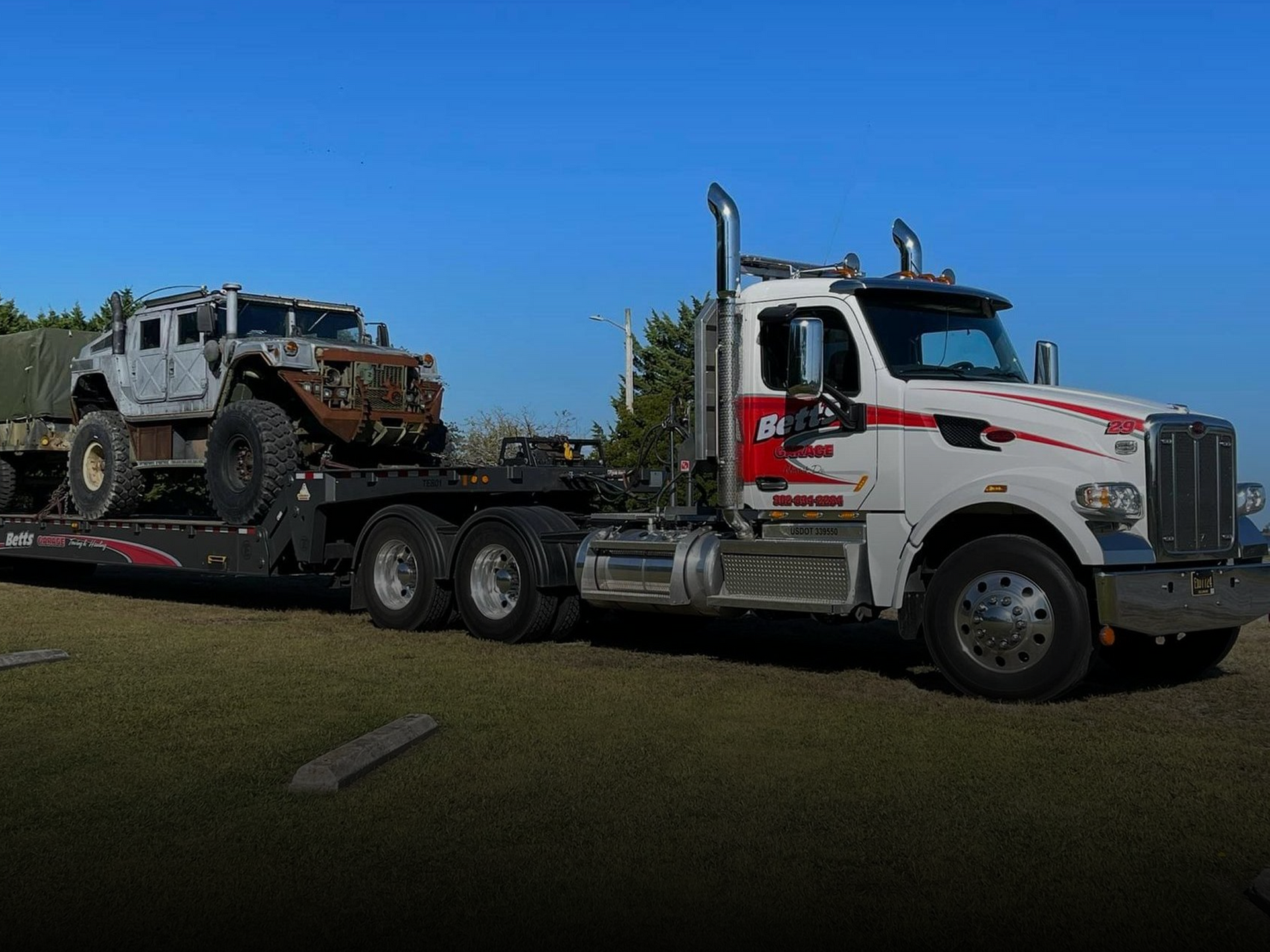 Heavy-duty tow truck hauling a damaged vehicle as part of B&G Auto Glass towing service.