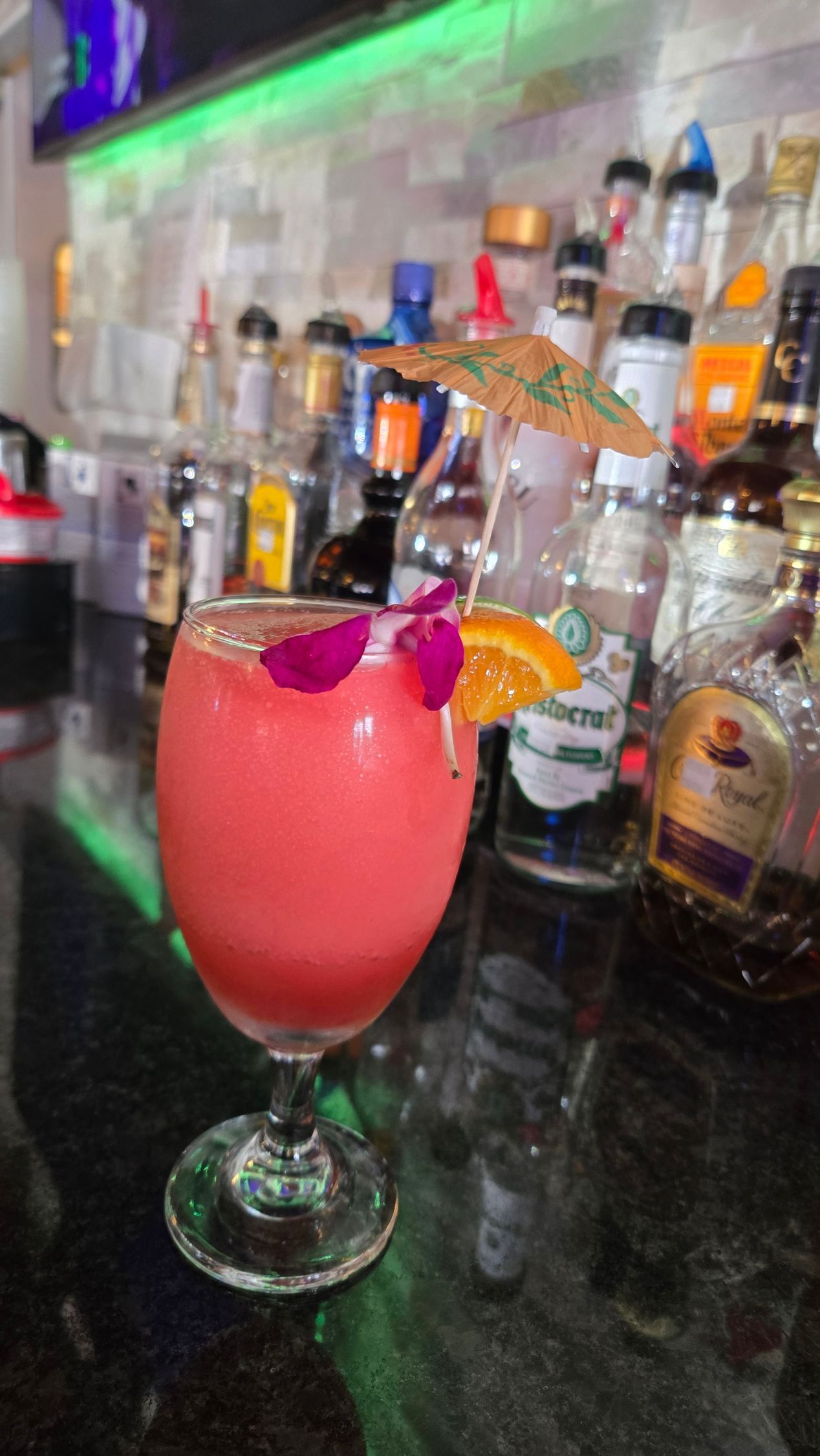 Burrito with toppings on a teal plate on a bar, bar in background. Burrito with toppings on a teal plate on a bar, bar in background.