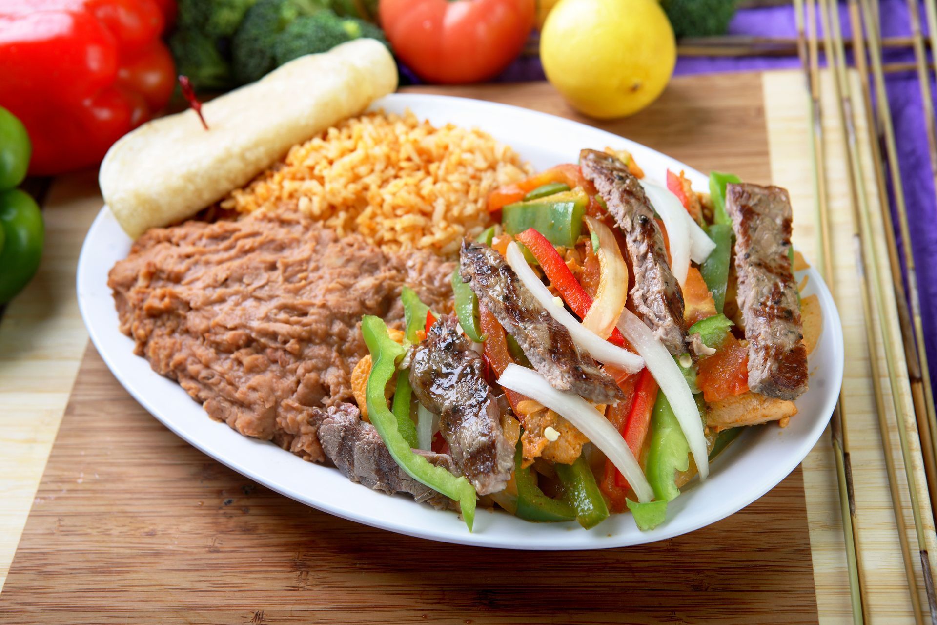 Plate with Mexican food: grilled meat, peppers, onions, rice, beans, breadstick. Plate with Mexican food: grilled meat, peppers, onions, rice, beans, breadstick.