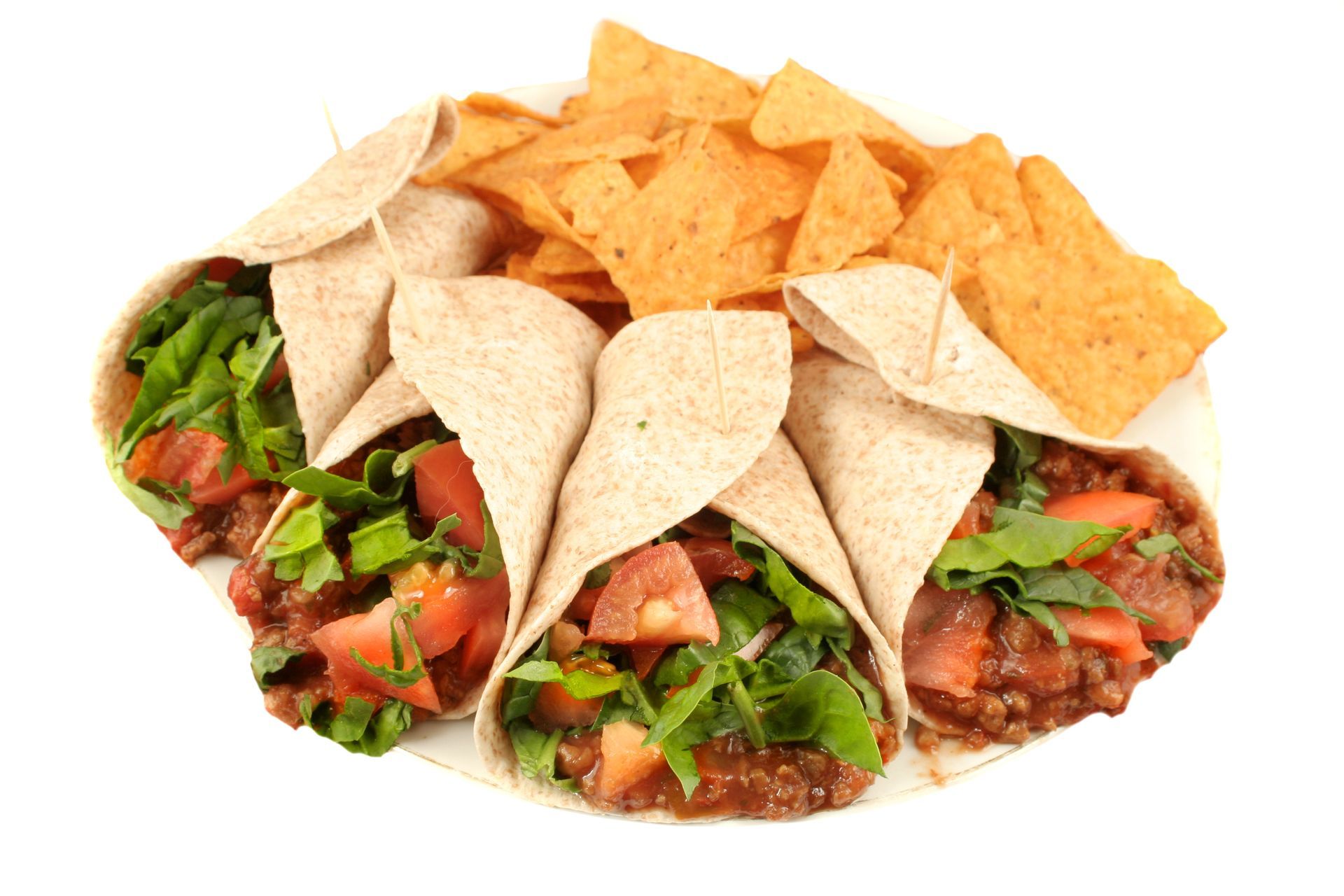 Tacos in tortillas with toppings and tortilla chips on a white plate.
