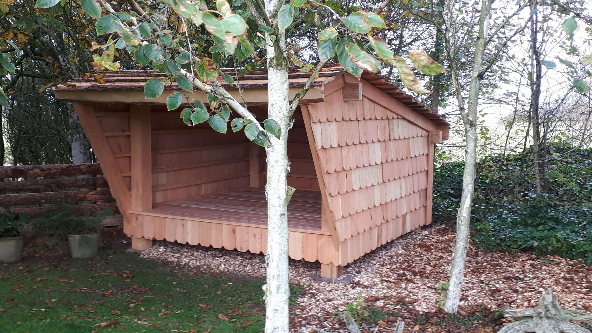 En lille træhytte står midt i en skov.