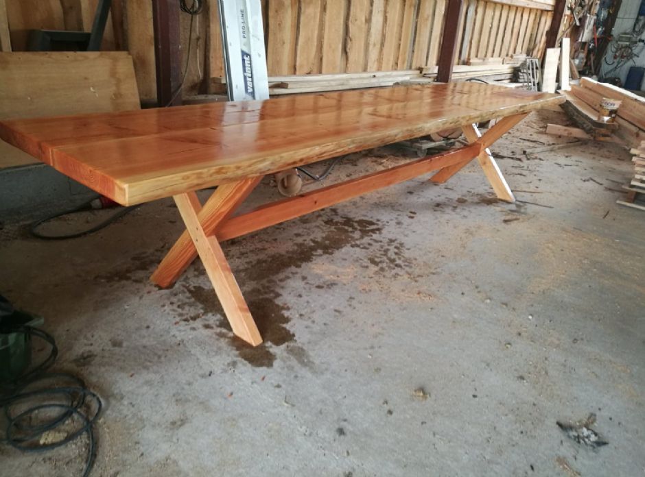 Et træbord sidder på et betongulv i en garage.