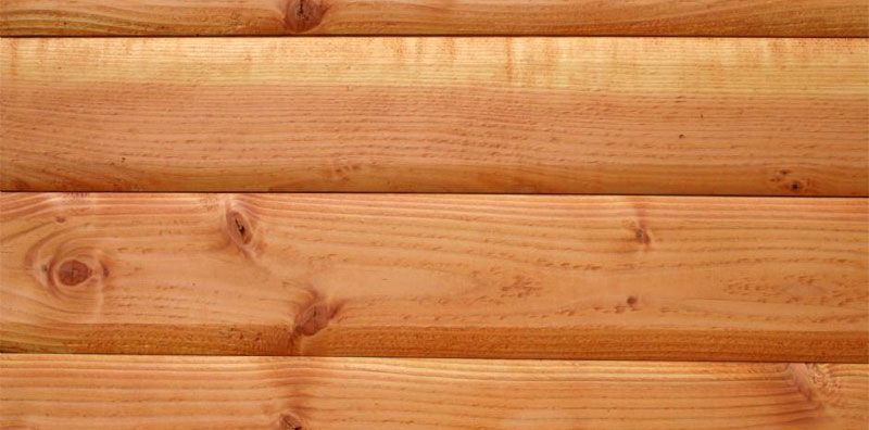 Et nærbillede af en trævæg lavet af logs.