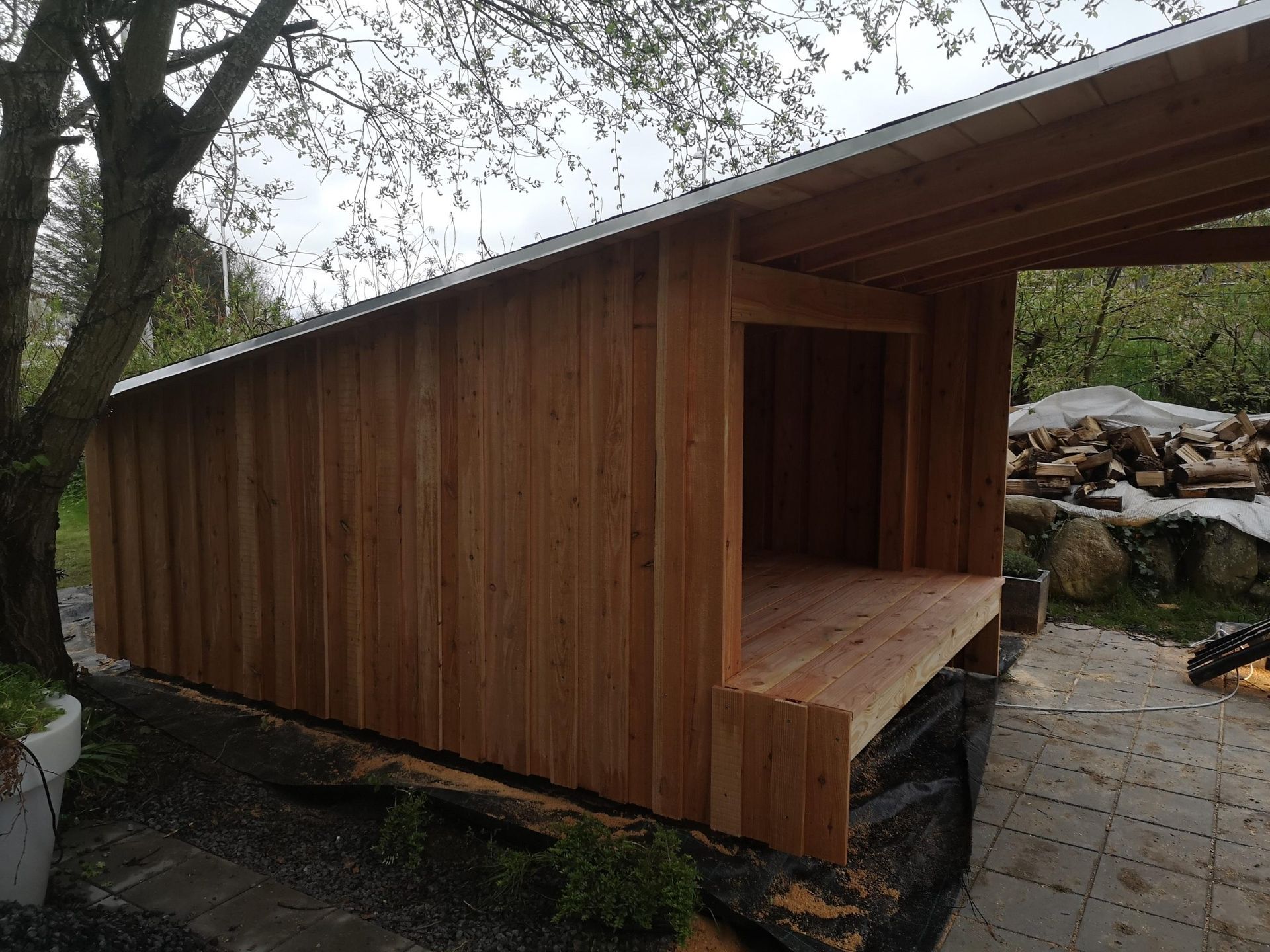 Der bygges et træskur med tag i en baggård.
