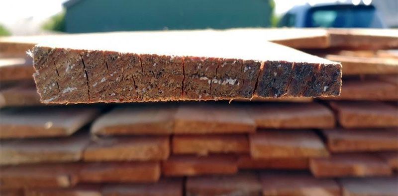 Nærbillede af et stykke træ, der sidder på toppen af ​​en bunke træ.