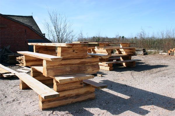 En flok træborde og bænke er stablet oven på hinanden