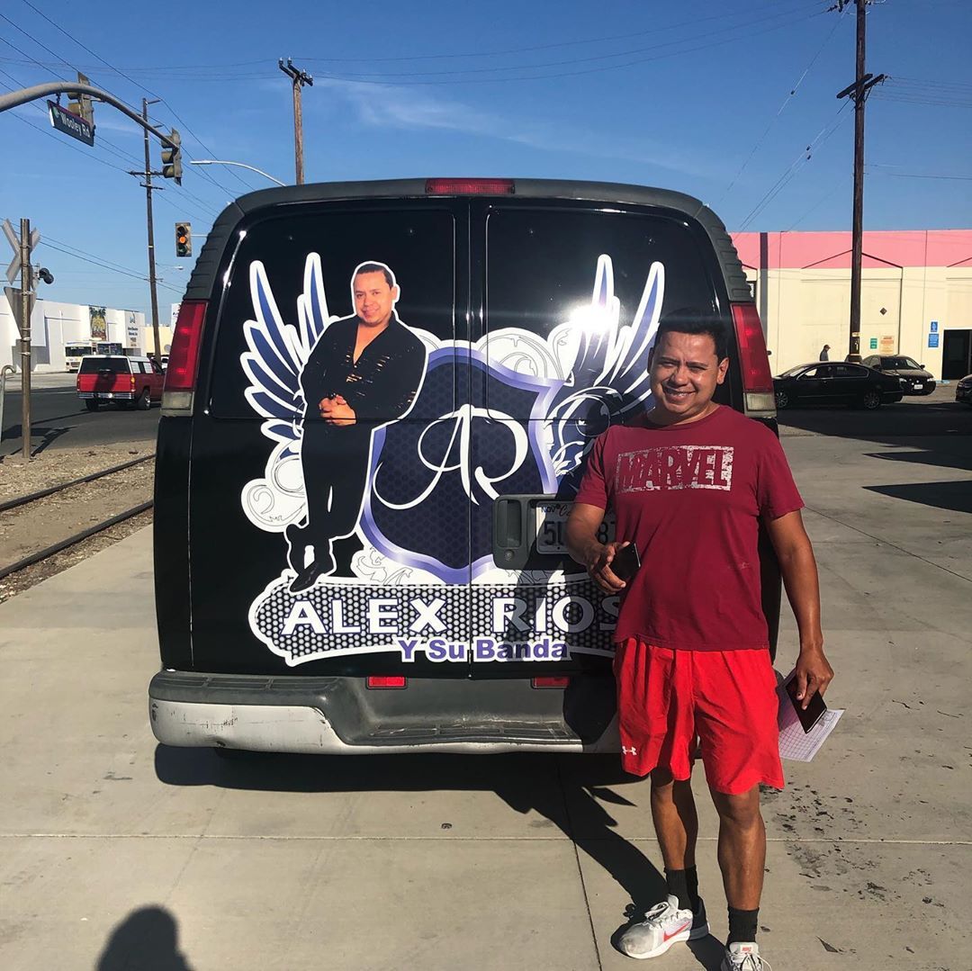 A man standing in front of a van that says alex rio