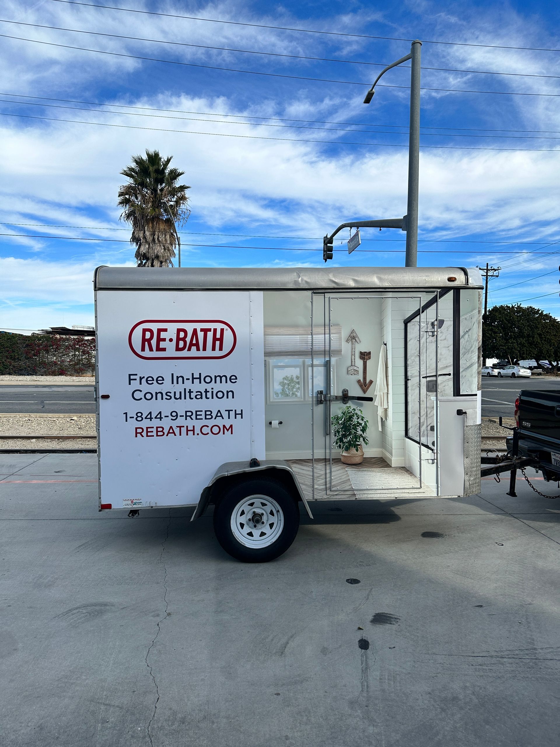 A re-bath trailer is parked in a parking lot