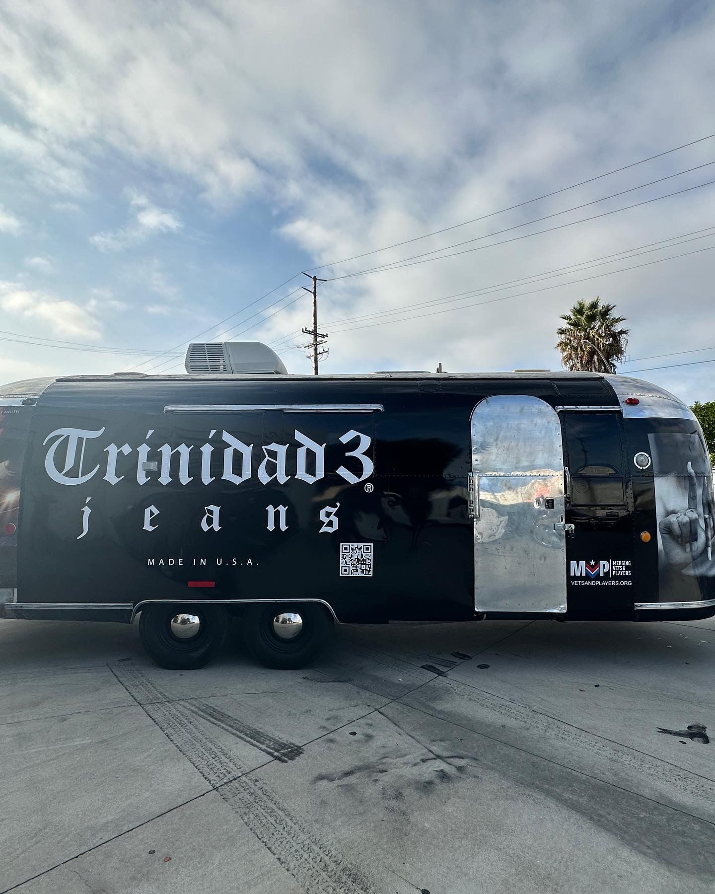 A trinidad 3 jeans trailer is parked in a parking lot