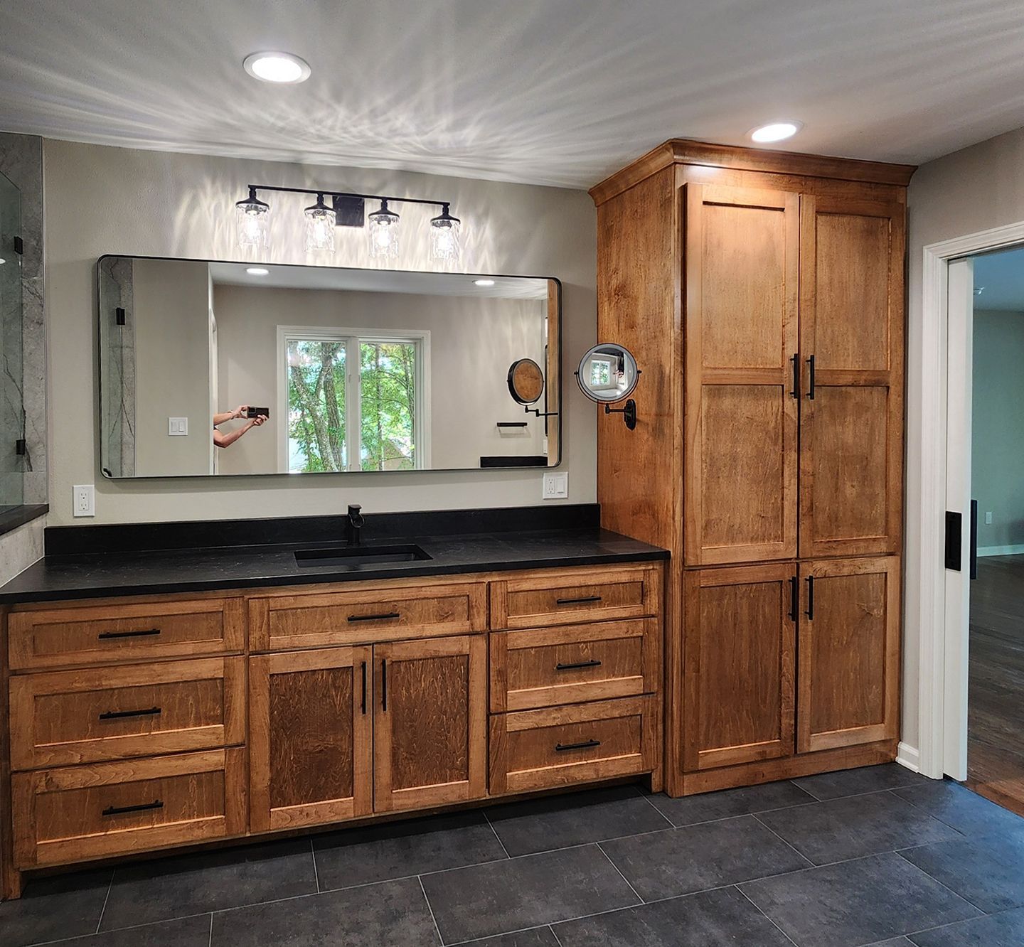 A bathroom with wooden cabinets and a large mirror