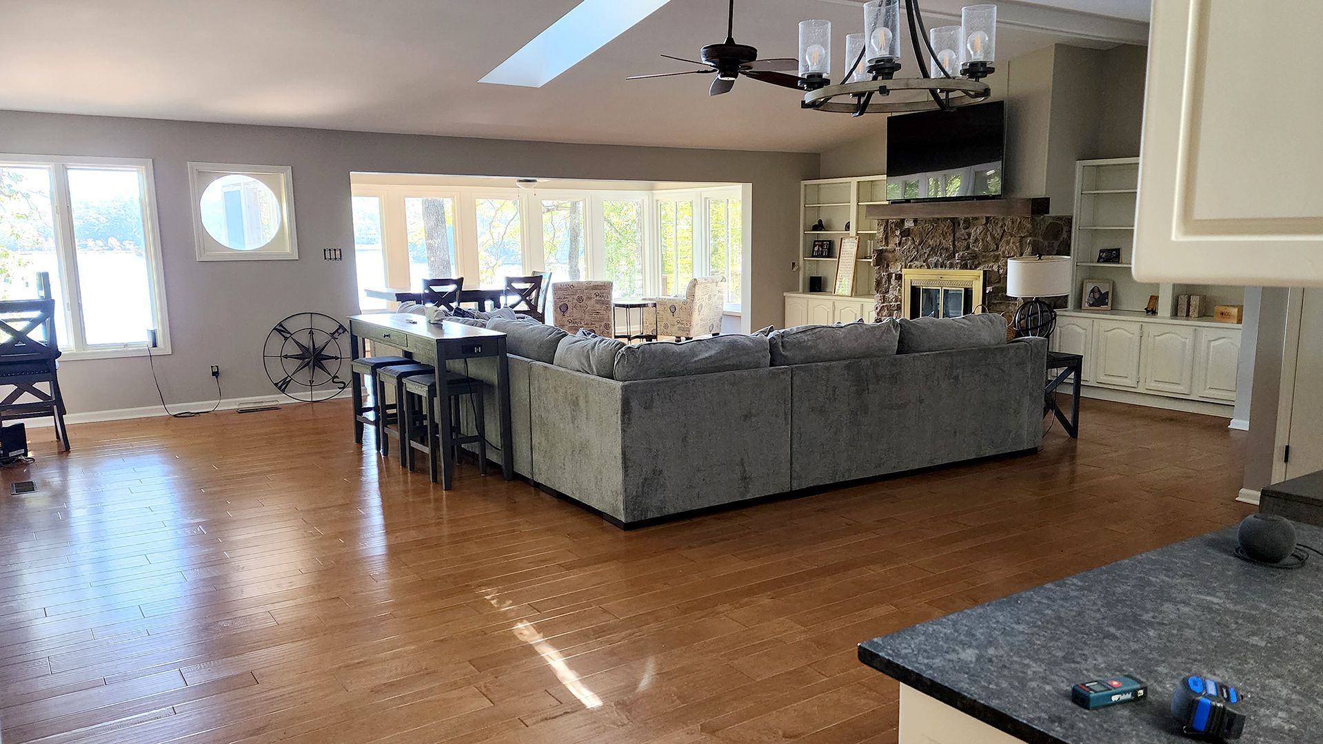 Spacious living room with hardwood floors, a large gray sectional, and a fireplace.