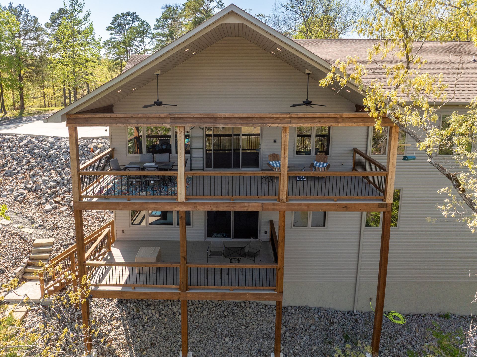 An aerial view of a house with a large deck surrounded by trees.