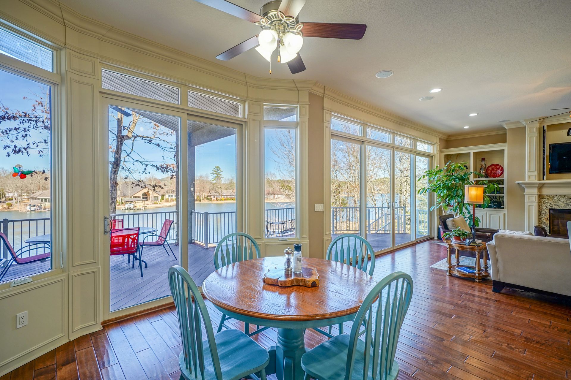 A living room with a table and chairs and a ceiling fan.