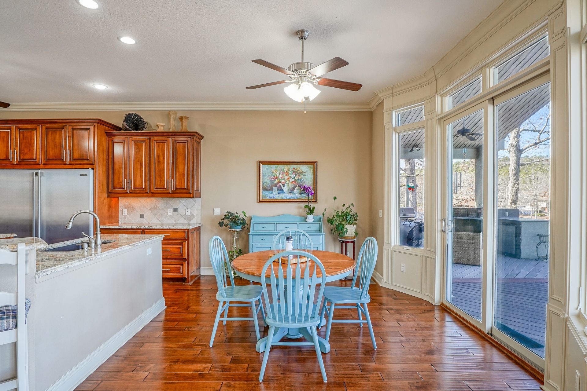 A kitchen with a table and chairs and a ceiling fan.
