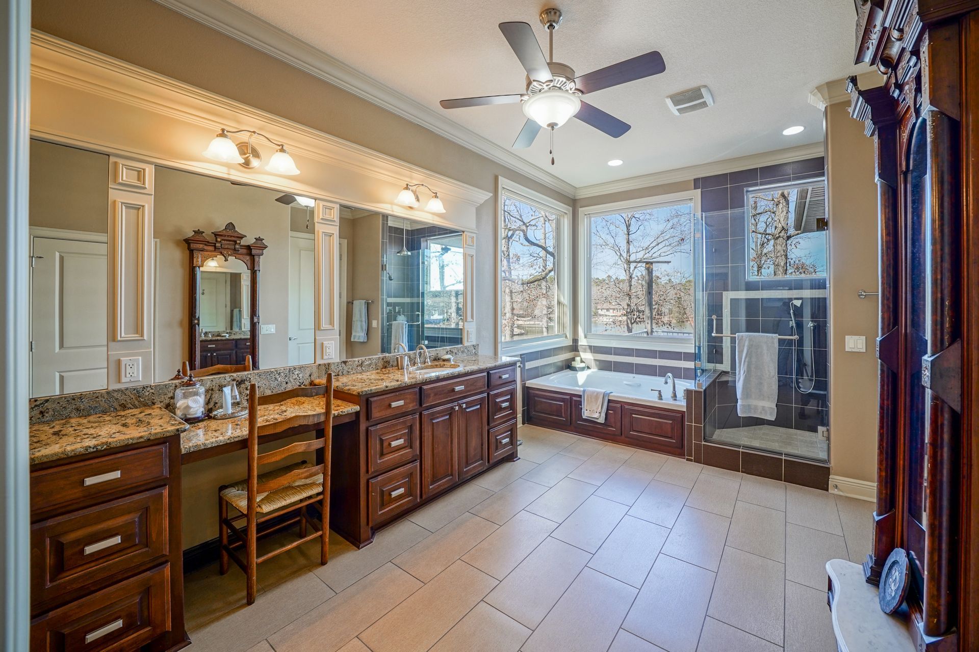 A large bathroom with two sinks , a tub , and a ceiling fan.