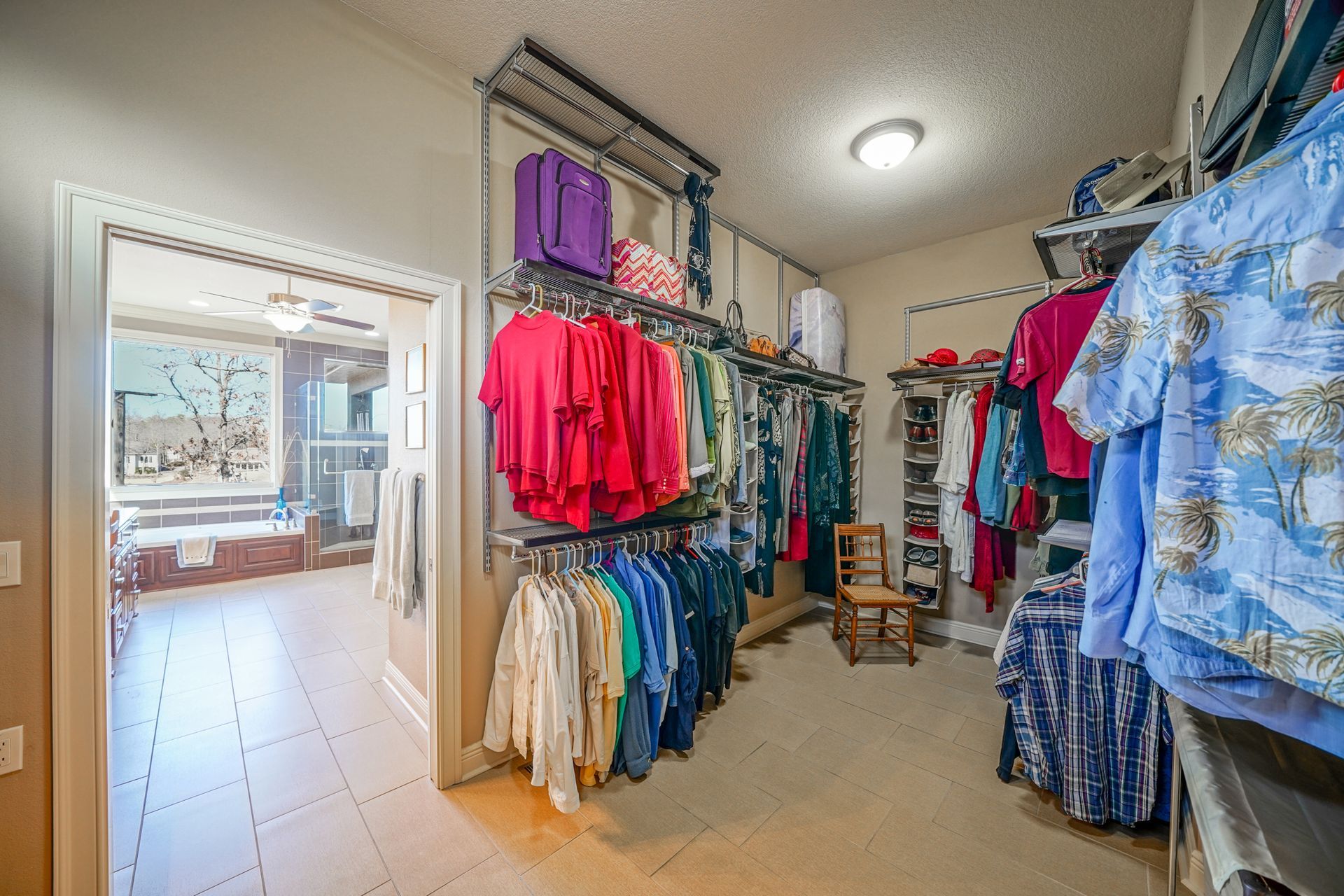 A walk in closet filled with lots of clothes and luggage.