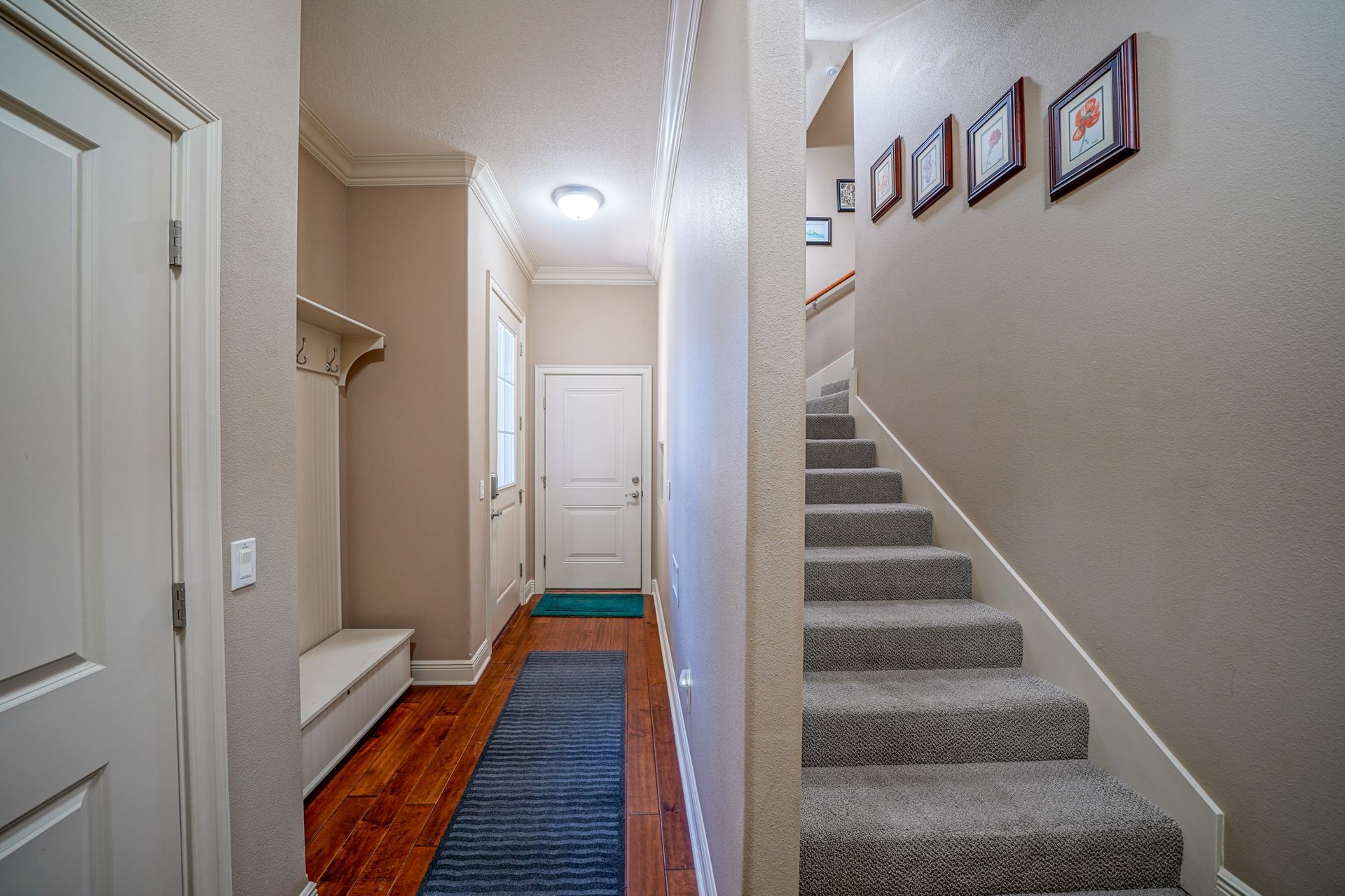 A hallway with stairs leading up to the second floor of a house.