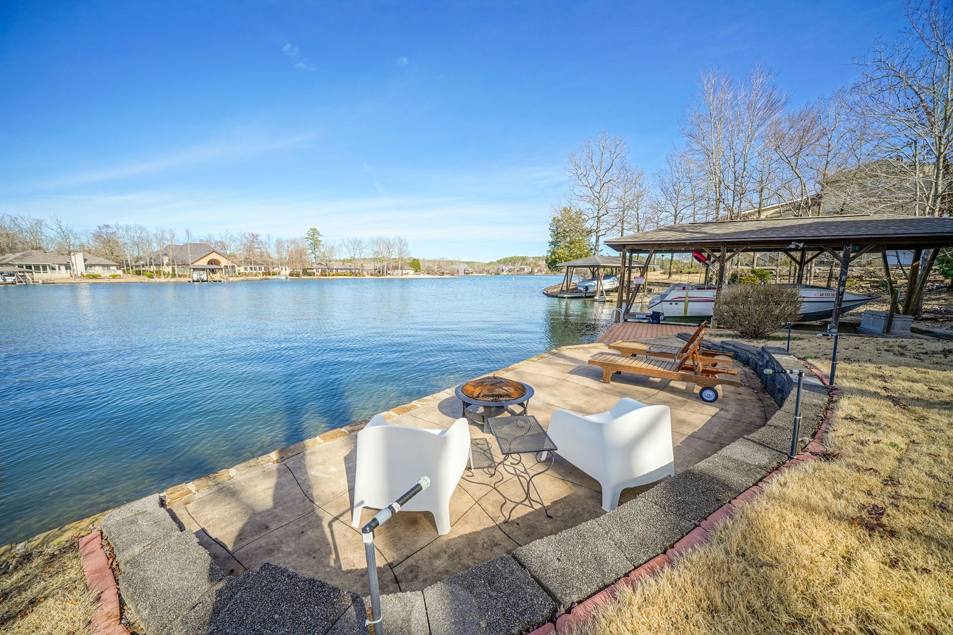 A fire pit is sitting on the shore of a lake.