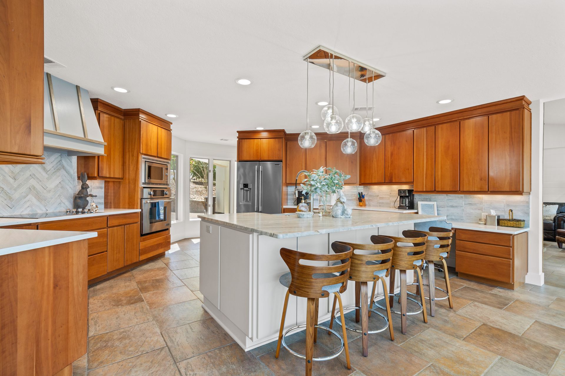 A kitchen with wooden cabinets , stainless steel appliances , and a large island.