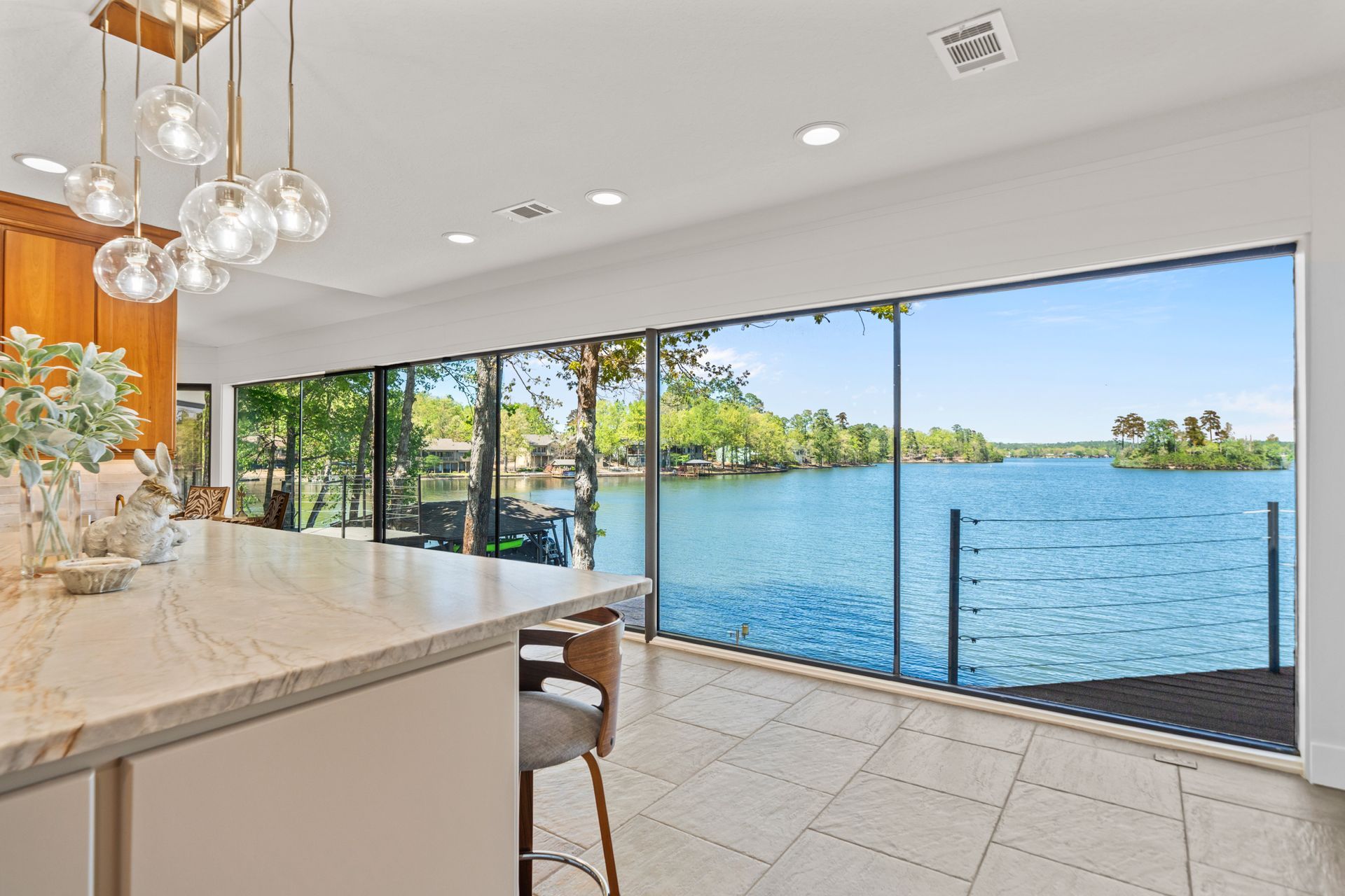 A kitchen with a large window overlooking a lake.