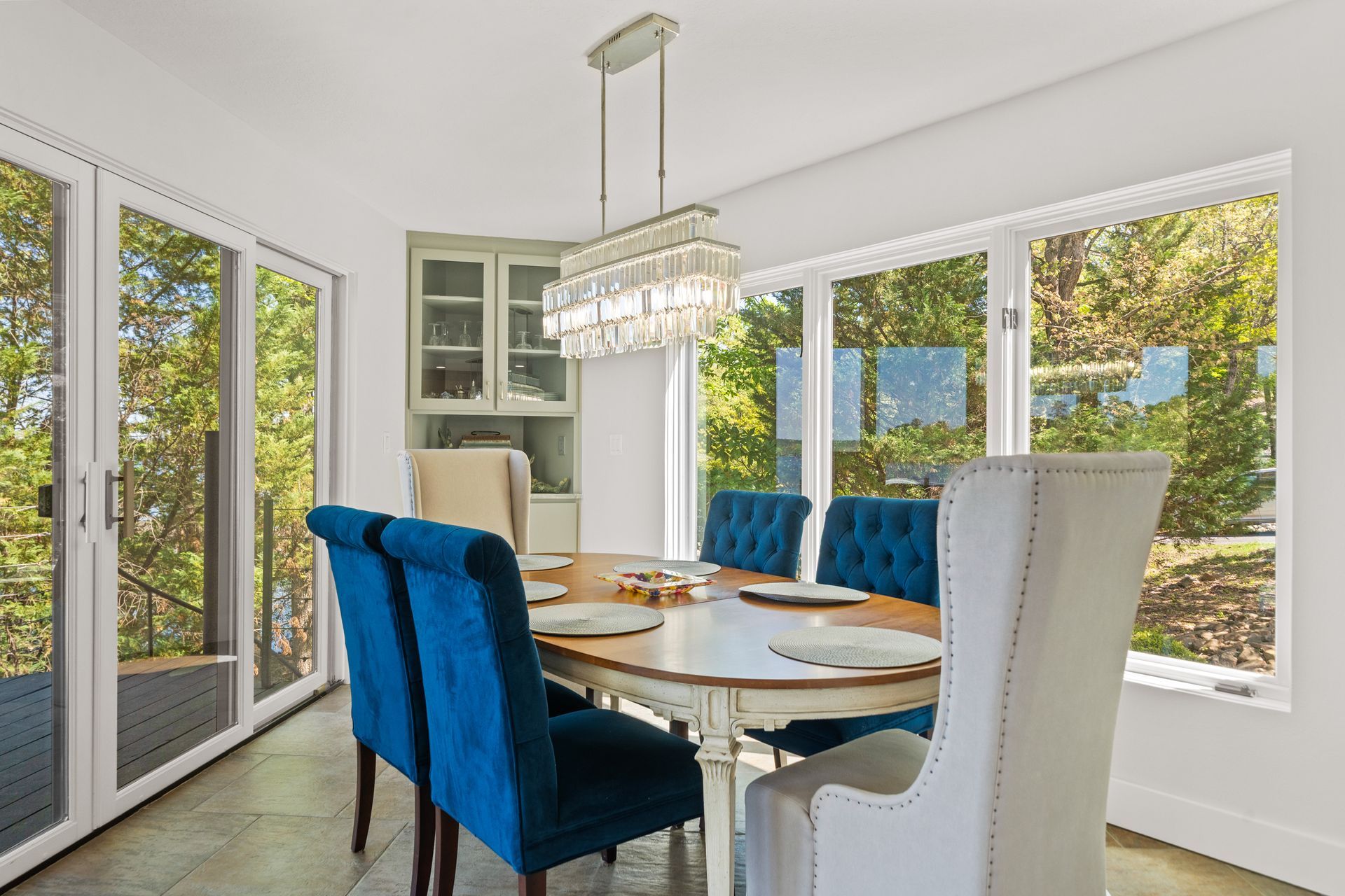 A dining room with a table and chairs and a chandelier.