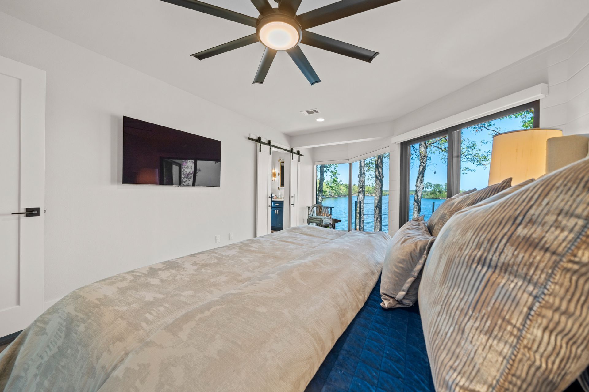 A bedroom with a large bed and a ceiling fan.