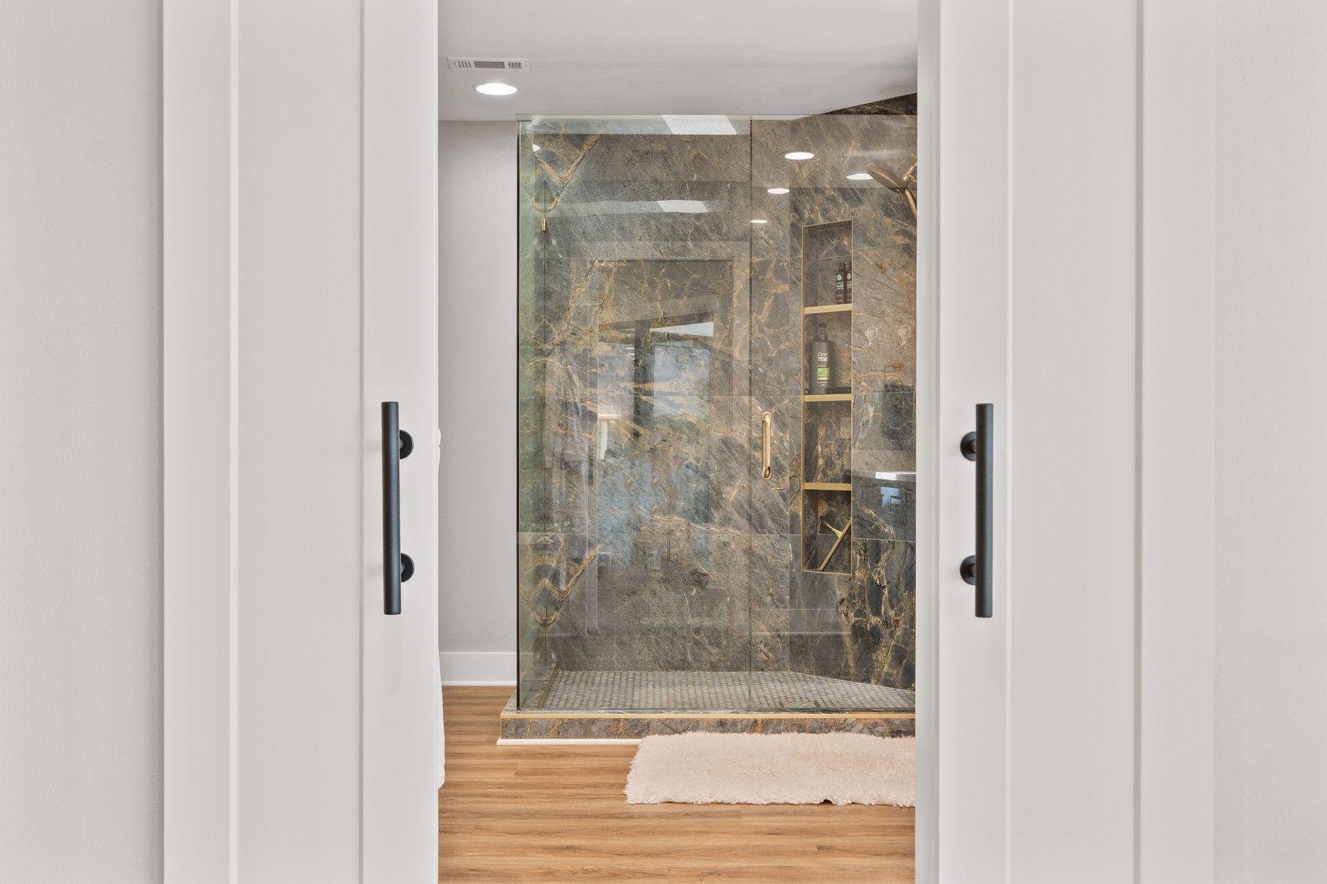 A bathroom with a walk in shower and sliding glass doors.