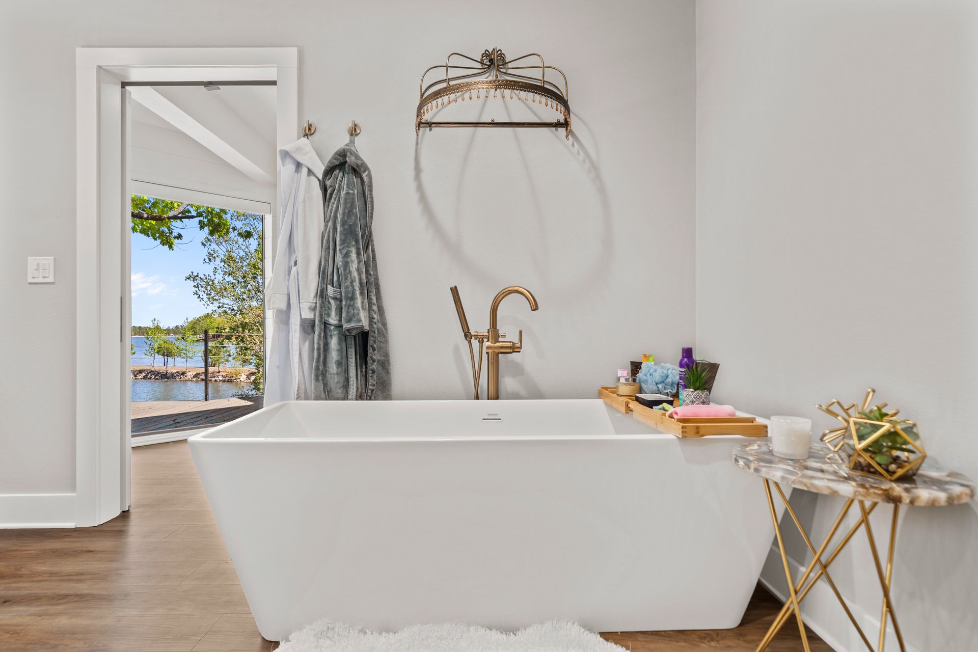There is a large bathtub in the bathroom with a view of the water.