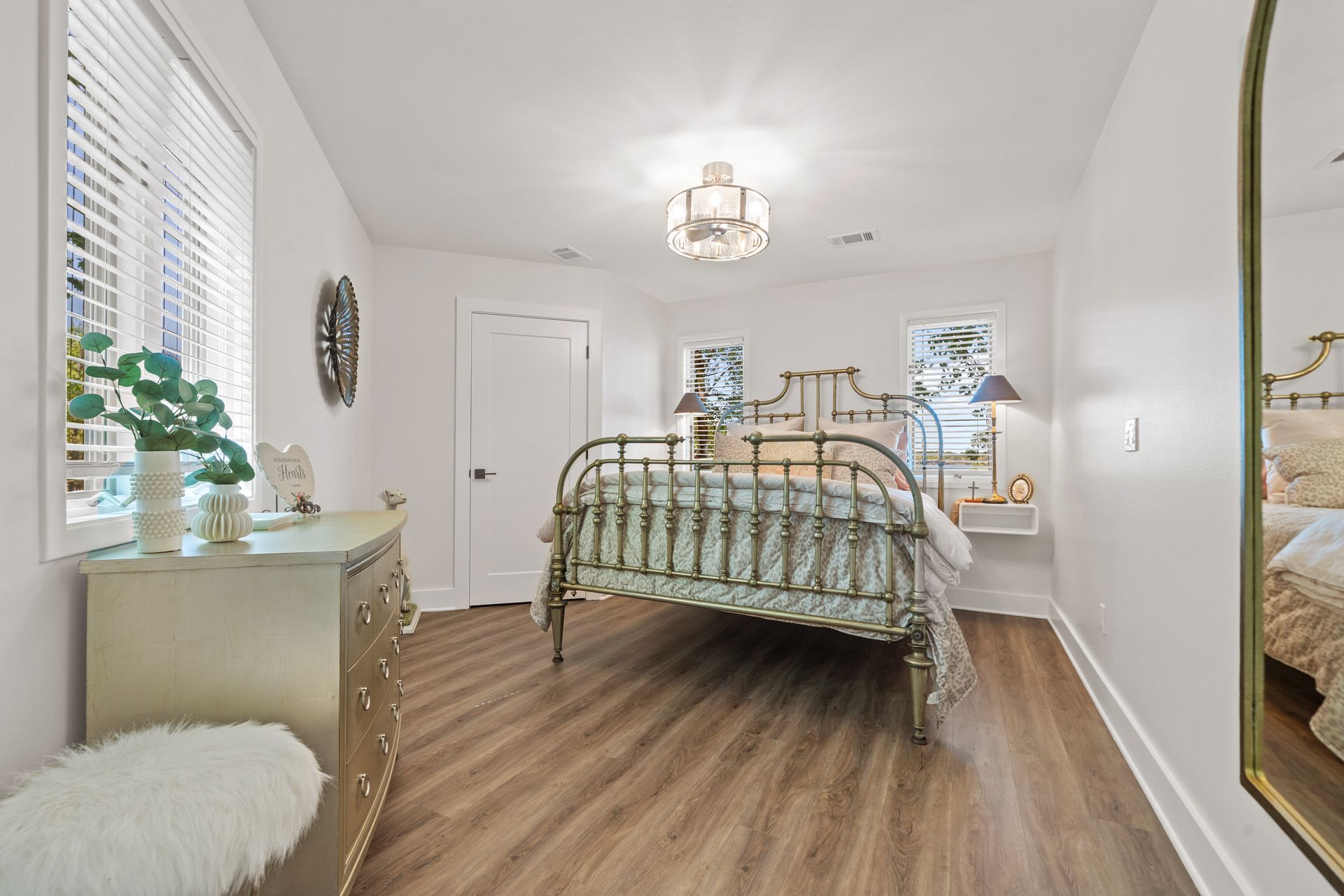 A bedroom with a bed , dresser , and mirror.