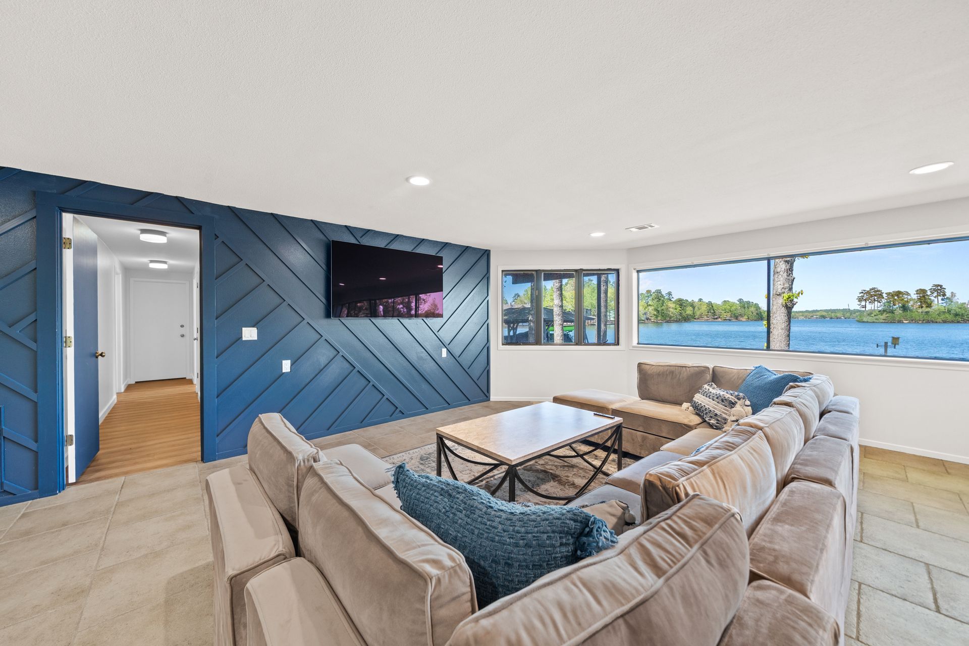 A living room with a couch and a television on the wall.